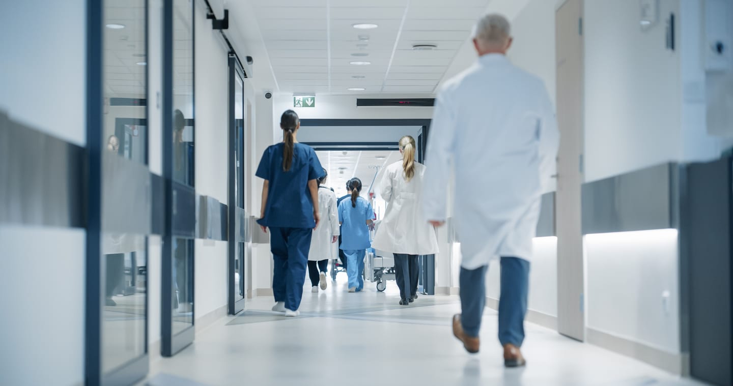 Médecins et infirmiers marchant dans un couloir d'hôpital lumineux